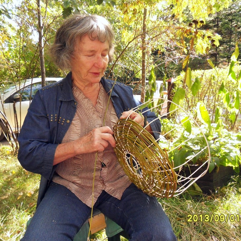 Irja flätar en blomkorg av bambu